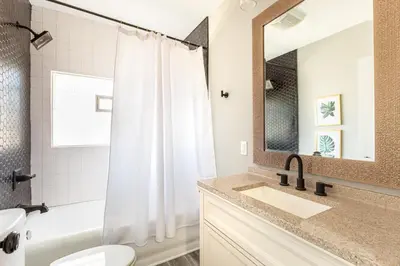 a bathroom with a sink and a toilet and a mirror at The 1920’s Dutch Colonial - Highland Square in Akron