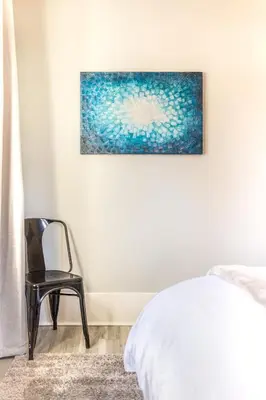 a bedroom with a chair and a painting on the wall at The 1920’s Dutch Colonial - Highland Square in Akron