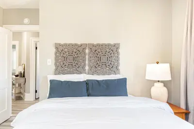 a bedroom with a large white bed with blue pillows at The 1920’s Dutch Colonial - Highland Square in Akron