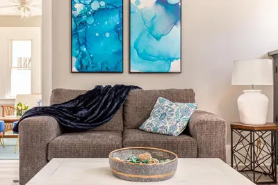 a living room with a couch and two paintings on the wall at The 1920’s Dutch Colonial - Highland Square in Akron