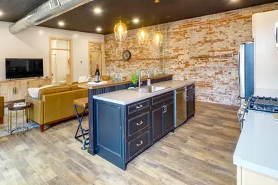 a kitchen with a sink and a living room at Downtown Millersburg Retreat with Sleek Interior! in Millersburg
