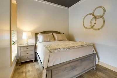a bedroom with a bed and a lamp and a mirror at Downtown Millersburg Retreat with Sleek Interior! in Millersburg
