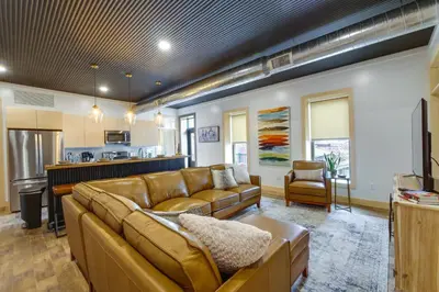 a living room with a couch and a kitchen at Downtown Millersburg Retreat with Sleek Interior! in Millersburg