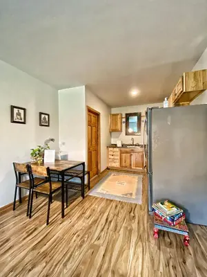 a kitchen with a table and a stainless steel refrigerator at Giriraja Ashraya in Moundsville