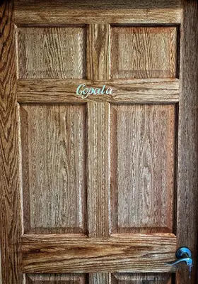 a wooden door with the word oporia written on it at Giriraja Ashraya in Moundsville