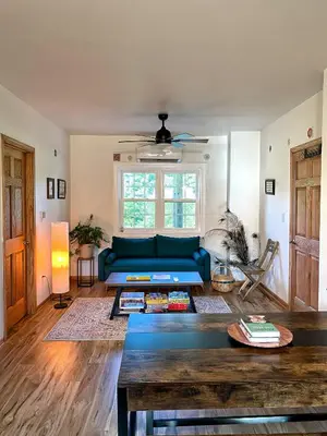 a living room with a blue couch and a table at Giriraja Ashraya in Moundsville