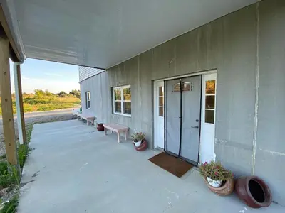 a building with a porch with benches and a door at Giriraja Ashraya in Moundsville