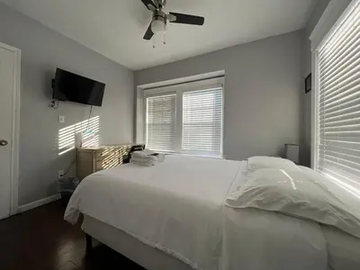 a bedroom with a white bed and a ceiling fan at Stay with Jay Cleveland One in Cleveland