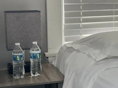 two bottles of water sitting on a table next to a bed at Stay with Jay Cleveland One in Cleveland