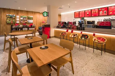a restaurant with tables and chairs in front of a counter at Doubletree by Hilton Newark in Newark