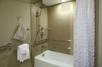 a bathroom with a shower and a tub and a sink at Doubletree by Hilton Newark in Newark