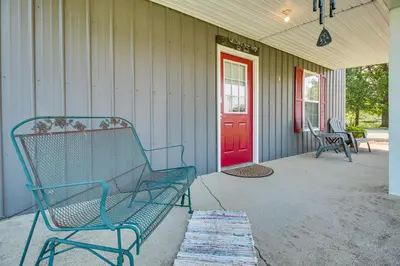 a blue bench sitting on a porch with a red door at Kentucky Retreat Near Williamstown Lake! in Williamstown