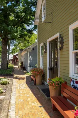 a house with two benches on a brick walkway at Country Squire inn and suites in Coshocton