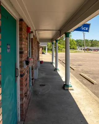 an empty building with columns and a sign on it at Country Squire inn and suites in Coshocton