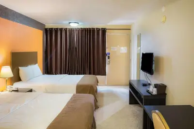 a hotel room with two beds and a television at Motel 75 Monroe in Monroe