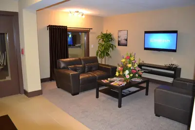 a living room with a leather couch and a tv at Motel 75 Monroe in Monroe