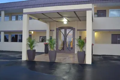 a building with two potted plants in front of it at Motel 75 Monroe in Monroe