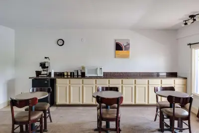 a room with two tables and chairs and a kitchen at Motel 75 Monroe in Monroe