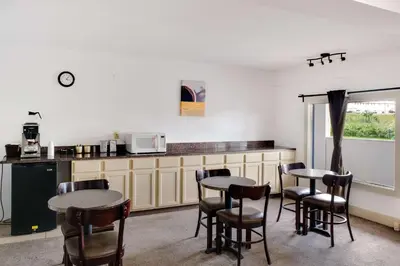 a kitchen with two tables and chairs and a counter at Motel 75 Monroe in Monroe