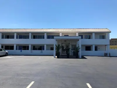a white building with a parking lot in front of it at Motel 75 Monroe in Monroe