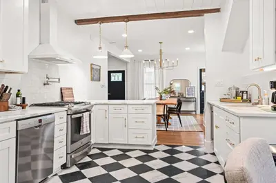 a kitchen with white cabinets and a checkered floor at 4BR for 10, Near Ark, High-Tech Kitchen, Parking! in Williamstown