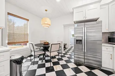 a kitchen with a table and a stainless steel refrigerator at 4BR for 10, Near Ark, High-Tech Kitchen, Parking! in Williamstown