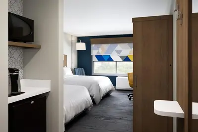 a hotel room with two beds and a window at Holiday Inn Express & Suites Lima by IHG in Lima