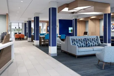 a lobby with a couch and chairs and tables at Holiday Inn Express & Suites Lima by IHG in Lima