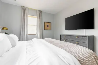 a bedroom with a white bed and a flat screen tv at Exclusive NEW Listing! Maple Heights Charm in Maple Heights