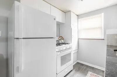 a white kitchen with a refrigerator and a stove at Exclusive NEW Listing! Maple Heights Charm in Maple Heights