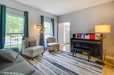 a living room with a piano and a chair at Spacious Lewis Center Home with Yard and Gas Grill! in Lewis Center