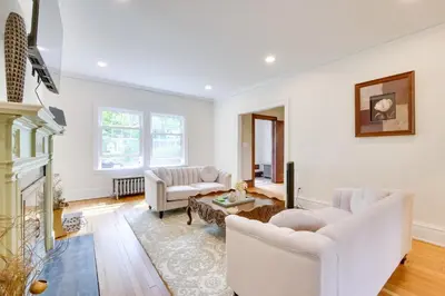 a living room with white furniture and a fireplace at Cleveland Heights Retreat Close to Everything! in Cleveland Heights