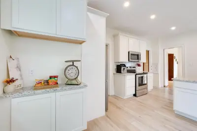 a kitchen with white cabinets and a clock on a counter at Cleveland Heights Retreat Close to Everything! in Cleveland Heights