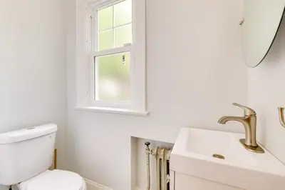 a bathroom with a toilet and a sink and a window at Cleveland Heights Retreat Close to Everything! in Cleveland Heights