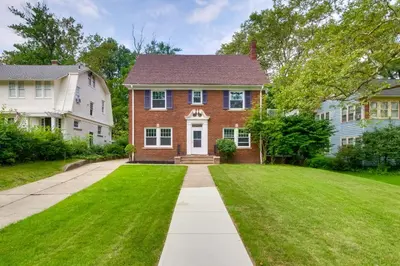 a red brick house with a grass yard at Cleveland Heights Retreat Close to Everything! in Cleveland Heights