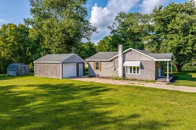 a house with a garage and a grass yard at 7 Mi to Mounds State Park Indiana Home with Porch! in Daleville