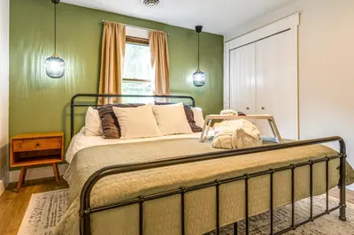 a bed in a bedroom with green walls at 7 Mi to Mounds State Park Indiana Home with Porch! in Daleville