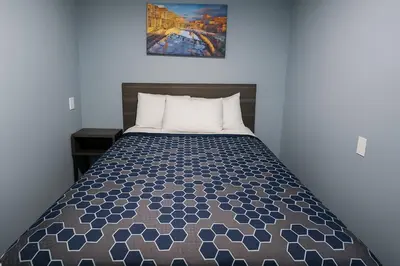 a bed in a bedroom with a picture on the wall at Hillsboro Inn & Suites in Hillsboro