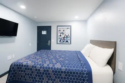 a bedroom with a bed and a flat screen tv at Hillsboro Inn & Suites in Hillsboro