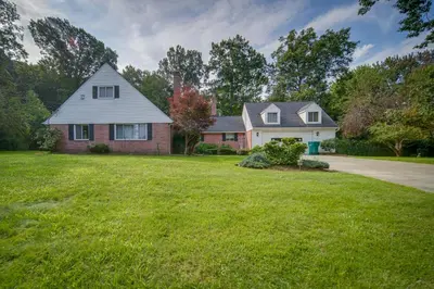 a house with a green lawn in front of a house at Richmond Heights Retreat with Patio and Fire Pit! in Richmond Heights