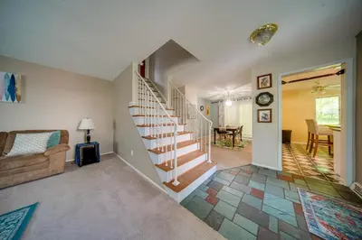 a living room with a staircase and a living room at Richmond Heights Retreat with Patio and Fire Pit! in Richmond Heights