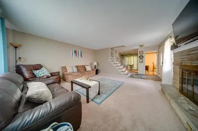 a living room with a leather couch and a fireplace at Richmond Heights Retreat with Patio and Fire Pit! in Richmond Heights