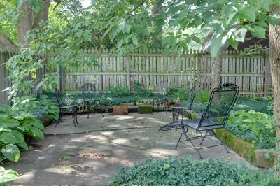 a garden with chairs and tables and a fence at Welcoming Willoughby Home 1 Mi to Historic Dtwn in Willoughby