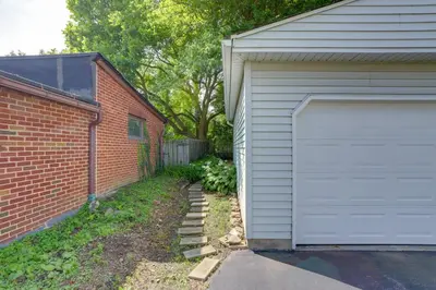 a garage door next to a brick building at Welcoming Willoughby Home 1 Mi to Historic Dtwn in Willoughby
