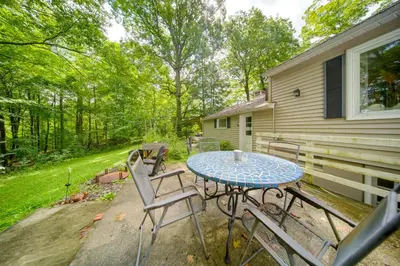 a patio with a table and chairs in front of a house at Stylish Willoughby Hills Retreat with Fireplace! in Willoughby Hills