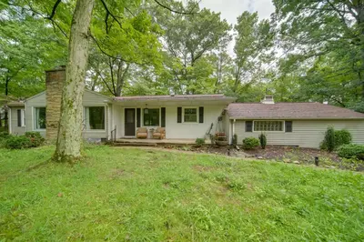 a white house with a tree in the yard at Stylish Willoughby Hills Retreat with Fireplace! in Willoughby Hills