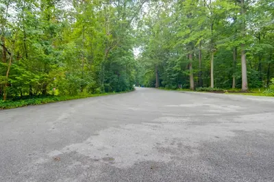 an empty road in the middle of a forest at Stylish Willoughby Hills Retreat with Fireplace! in Willoughby Hills