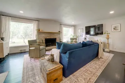 a living room with a blue couch and a fireplace at Stylish Willoughby Hills Retreat with Fireplace! in Willoughby Hills