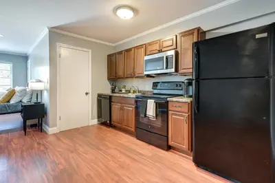 a kitchen with a black refrigerator and wooden cabinets at Toledo Vacation Rental about 5 Mi to Downtown! in Toledo