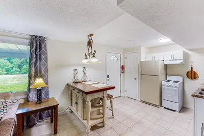 a kitchen with a table and a refrigerator at River Access! Couples Retreat on Working Homestead in Woodburn